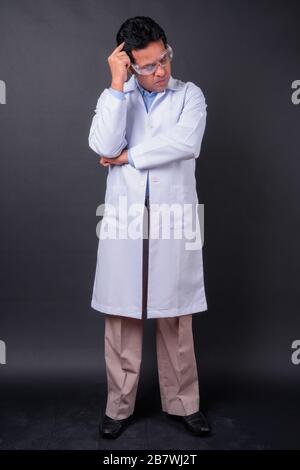 Medico uomo indiano maturo contro sfondo nero Foto Stock