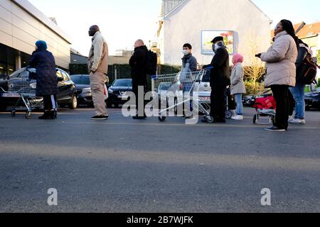 Bruxelles, Belgio. 18 Marzo 2020. Gli acquirenti si trovano in coda al di fuori di un supermercato prima che il governo belga imponga un blocco di coronavirus. Credit: ALEXANDROS MICHAILIDIS/Alamy Live News Foto Stock