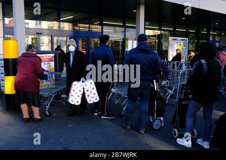 Bruxelles, Belgio. 18 Marzo 2020. Gli acquirenti si trovano in coda al di fuori di un supermercato prima che il governo belga imponga un blocco di coronavirus. Credit: ALEXANDROS MICHAILIDIS/Alamy Live News Foto Stock