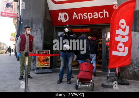 Bruxelles, Belgio. 18 Marzo 2020. Una guardia controlla l'ingresso di un supermercato prima che il governo belga imponga un blocco di coronavirus. Credit: ALEXANDROS MICHAILIDIS/Alamy Live News Foto Stock