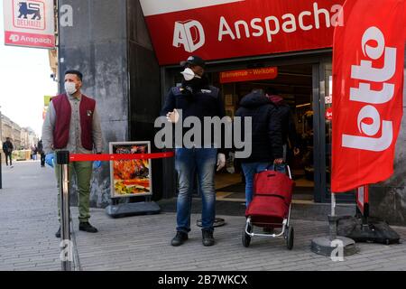 Bruxelles, Belgio. 18 Marzo 2020. Una guardia controlla l'ingresso di un supermercato prima che il governo belga imponga un blocco di coronavirus. Credit: ALEXANDROS MICHAILIDIS/Alamy Live News Foto Stock