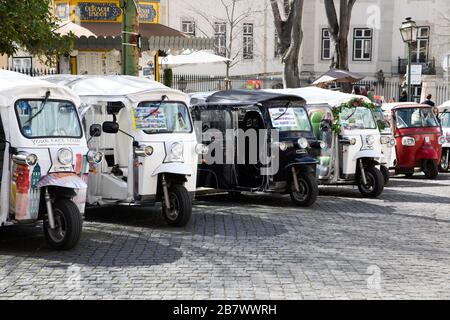 Tuk Tuks, rickshaws auto, parcheggiato pronto a dare visite guidate a Lisbona, capitale del Portogallo Foto Stock