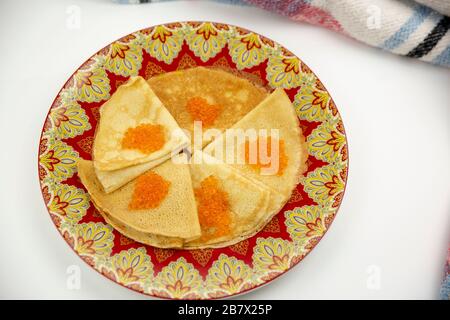 Bellissimo piatto con frittelle e caviale su sfondo bianco Foto Stock