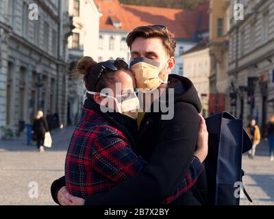 Giovane coppia spaventato che indossa una maschera di protezione del viso nel centro della città da quando è emerso il nuovo coronavirus Sars-cov-2 (Covid 19). Foto Stock