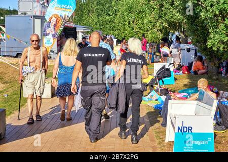 Guardia di sicurezza maschile e femminile in una festa estiva. Foto Stock