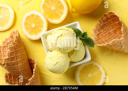 Gelato, limone e waffle su sfondo giallo, vista dall'alto Foto Stock