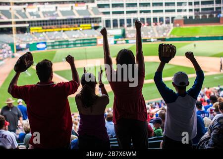 La famiglia a fare il tifo per una partita di baseball a uno stadio sportivo. Foto Stock