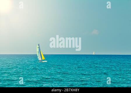 Piccola barca a vela personale in mare aperto in piano in una giornata estiva. Calma stagione con cielo blu. Giornata di sole nel mar mediterraneo a Tel Aviv Foto Stock