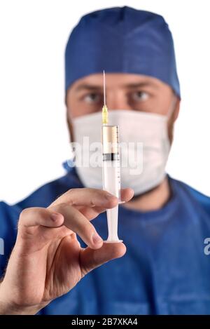 Foto studio completamente isolata da un giovane medico maschile con siringa in mano. Messa a fuoco selettiva sulla siringa. Foto Stock