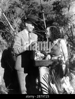 Giovane sceneggiatore e futuro regista JOHN FARROW visita MAUREEN o'SULLIVAN in costume come Jane Parker on set candid durante le riprese di TARZAN E IL SUO COMPAGNO 1934 registi CEDRIC GIBBONS e JACK CONWAY personaggi EDGAR RICE BURROUGHS Foto di TED ALLAN Metro Goldwyn Mayer Foto Stock