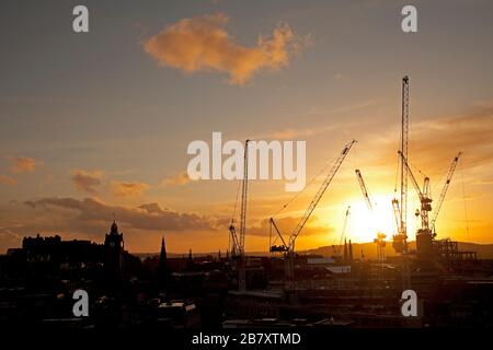 Edimburgo, Scozia, Regno Unito. 18th Mar 2020. Tramonto colorato sul centro della città. L'architettura storica del castello e la torre dell'orologio dell'Hotel Balmoral e il sito di costruzione industriale che è Edinburgh St James Centre. Foto Stock
