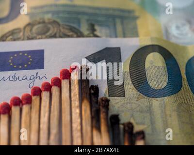 Fiammiferi bruciati. Concetto astratto di crollo del mercato azionario su 100 Euro nota, piatto Foto Stock