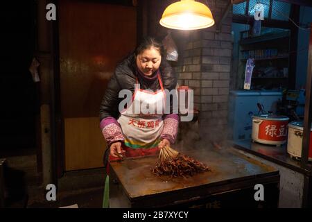 Wuhan, Cina, nella provincia di Hubei, è stato ucciso nel 2013, mostrando ai suoi stallholder la preparazione e il servizio di cibi cotti. Foto Stock