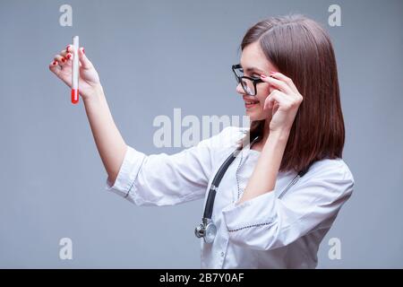 il medico tiene una provetta con il campione di sangue per il test del coronavirus Foto Stock