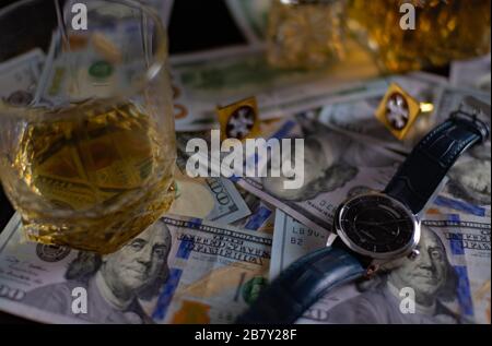 Whisky, orologio, dollari e gemelli per una camicia su un tavolo Foto Stock