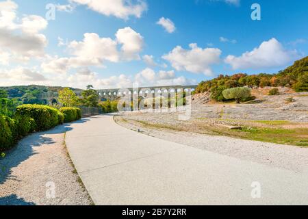 Un sentiero conduce all'antico acquedotto romano di Pont du Gard sul fiume Gardon, nella regione della Provenza del sud della Francia. Foto Stock