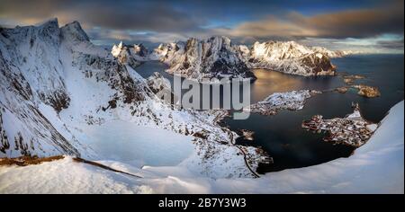 Vista dalla cima di Reinebringen sul villaggio di Reine e fiordo in inverno innevato, Lofoten Foto Stock