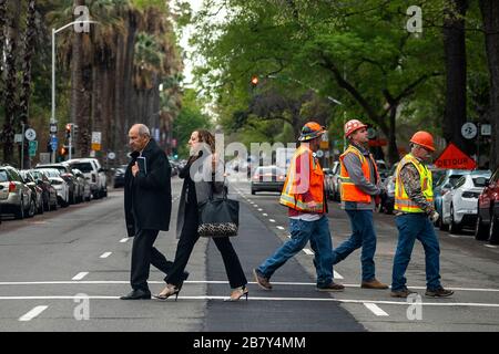 Sacramento, CA, Stati Uniti. 18 Marzo 2020. La gente cammina a meno di 6 piedi di distanza attraversando N Street alla 11th Street durante l'epidemia di coronavirus mercoledì 18 marzo 2020 a Sacramento. Credit: Paul Kitagaki Jr./ZUMA Wire/Alamy Live News Foto Stock