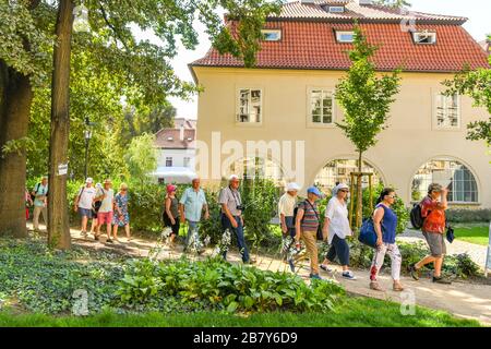 PRAGA, REPUBBLICA CECA - LUGLIO 2018: Gruppo di turisti in un giro turistico a piedi attraverso un parco e giardini nel centro di Praga. Foto Stock
