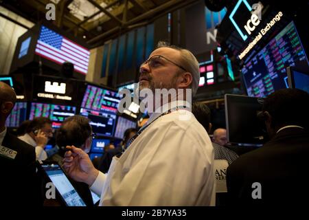 New York, Stati Uniti. 18 Marzo 2020. I commercianti lavorano alla Borsa di New York (NYSE) a New York, negli Stati Uniti, il 18 marzo 2020. Il New York Stock Exchange (NYSE) ha detto mercoledì che chiuderà temporaneamente il suo trading floor e si sposterà verso il commercio elettronico a causa dello scoppio del COVID-19. Credit: Michael Nagle/Xinhua/Alamy Live News Foto Stock