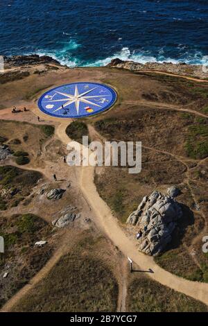 Immagine verticale di una grande bussola blu costruita sulla riva di fronte all'oceano a la Coruna, Spagna Foto Stock