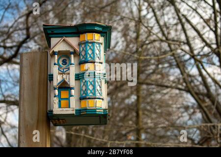 Una casa di uccelli teal e bianchi dettagliata in una foresta morta Foto Stock