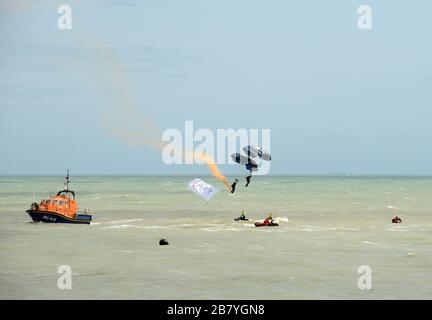 I membri del team di visualizzazione del paracadute dell'Esercito Tigers completano il loro salto e atterrano in mare durante l'Eastbourne Airshow, Sussex, Regno Unito Foto Stock