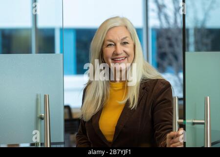 Uomo d'affari sorridente che apre la porta in ufficio Foto Stock