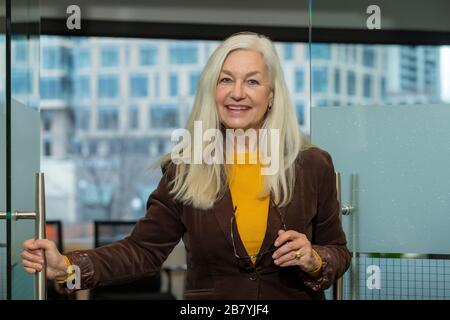 Uomo d'affari sorridente che apre la porta in ufficio Foto Stock