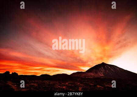 Tramonto con il cielo bello e i colori alle montagne con vista sul gigante El teide vulcan cima nel parco nazionale della Spagna Foto Stock