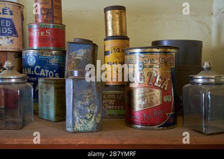 Una pila, una disposizione di natura morta di vari prodotti secchi vecchi e arrugginiti, scatole di cibo e bottiglie. Al Woolpack Museum di Holbrook, Australia. Foto Stock