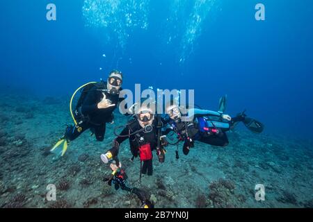 Tre subacquei (MR) posano per un ritratto alle Hawaii. Foto Stock