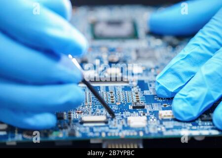 Asian tecnico riparazione circuito micro scheda principale del computer tecnologia elettronica : hardware, telefono cellulare, aggiornamento, concetto di pulizia. Foto Stock