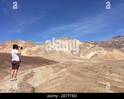 Uomo che fotografa la tavolozza Artisti al Death Valley National Park in California USA Foto Stock