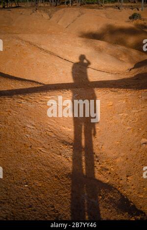 ombra dell'uomo a terra nelle dune rosse del deserto Foto Stock