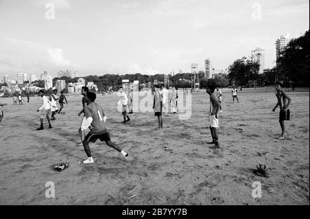 Ragazzi che giocano a calcio sulla spiaggia, Chowpatty, Girgaon, Bombay, Mumbai, Maharashtra, India, Asia Foto Stock