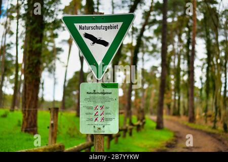 Segno triangolare verde con aquila e segno con regole di comportamento per la Riserva Naturale tedesca, una categoria di area protetta in Germania`s Feder Foto Stock