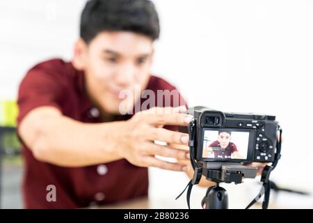 Giovani asiatici blogger maschio di impostazione della telecamera per la registrazione live di vlog video tutorial session a casa. Esso blogging o vlogging, social media broadca hobby Foto Stock