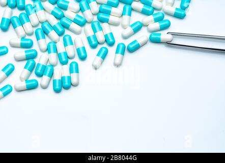 Forcipe prelevare la capsula bianco-blu dal gruppo di pillole. Farmaci scegliere. Selezione di farmaci antibiotici. Concetto di resistenza ai farmaci antibiotici. QA e QC Foto Stock