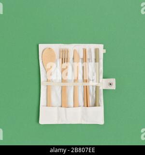 Set di posate di bambù in una custodia su sfondo verde pastello. Concetto di zero sprechi. Foto Stock