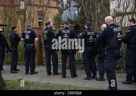 Berlino, Germania. 19 Mar 2020. I poliziotti sono in piedi fuori da un cancello anteriore durante un raid. Dopo il divieto del gruppo dei cittadini del Reich "popoli e tribù della Germania unita", le incursioni si sono svolte in diversi stati. Credit: Paul Zinken/dpa/Alamy Live News Foto Stock