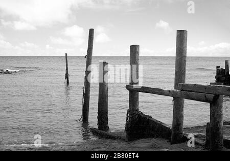 Castle Haven, Reeth Bay, Isola di Wight, Inghilterra, Regno Unito: Guardando fuori sul canale inglese in una giornata tranquilla, con una vecchia frangiflutti in primo piano. Fotografia a pellicola in bianco e nero Foto Stock