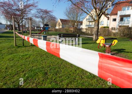 Rot-weisses Absperrband an einem gesperrten Kinderspielplatz während der Corona-Krise in Deutschland Foto Stock