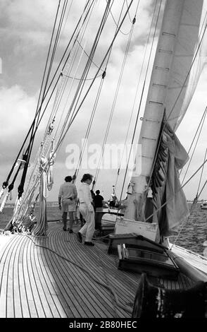 Il ponte che guarda indietro a bordo dello yacht di classe J 'Velsheda' dopo la prima riattaccatura, vela nel Solent, Hampshire, Inghilterra, Regno Unito, estate 1991. Archivia la fotografia di film in bianco e nero Foto Stock