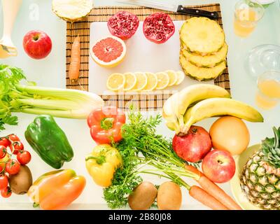 Composizione con verdure bio-biologiche e frutta - tavolo da cucina vista dall'alto con colazione pasto per vegetariani e vegani - stile di vita sano co Foto Stock