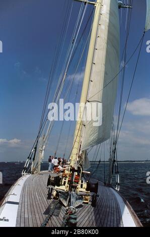 Il ponte che guarda a poppa dalle fiancate dello yacht di classe J 'Velsheda' dopo la prima rifalla, navigando nel Solent, Hampshire, Inghilterra, Regno Unito, estate 1991. Archivia la fotografia di pellicola trasparente Foto Stock