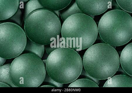 Integratori vitaminici e minerali per vegetariani spirulina in compresse su fondo bianco, primo piano Foto Stock