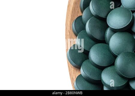 Integratori vitaminici e minerali per vegetariani spirulina in compresse in un cucchiaio di legno, primo piano Foto Stock