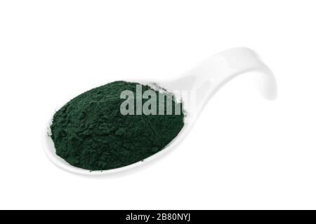 Integratori vitaminici e minerali per i vegetariani in polvere di spirulina in un cucchiaio di ceramica, primo piano Foto Stock