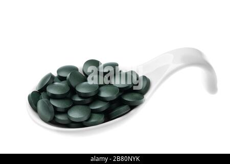 Integratori vitaminici e minerali per vegetariani spirulina in compresse in un cucchiaio di ceramica, primo piano Foto Stock